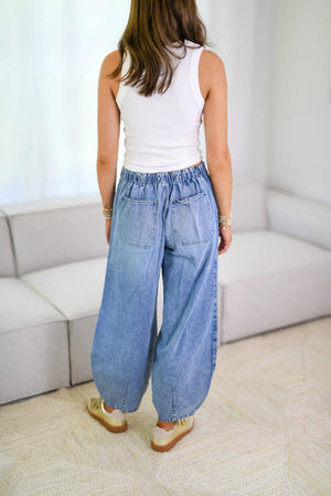 Light wash denim balloon-leg jeans with drawstring waist and back pockets.