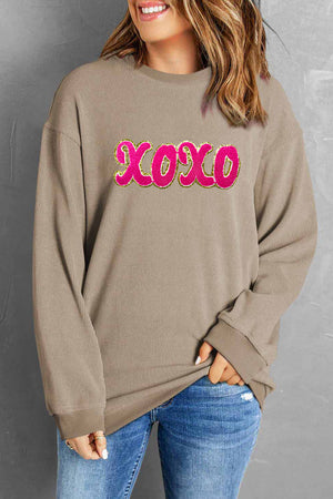 Tan ribbed sweatshirt with pink XOXO appliqué detail