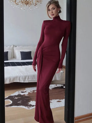Burgundy turtleneck maxi dress with long sleeves and a ruched tie detail on the side.