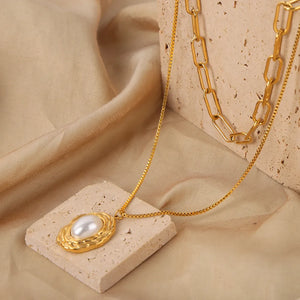 Gold double-layered necklace with pearl pendant and paperclip chain.