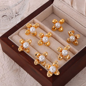 Gold petal pearl stud earrings with a flower design.