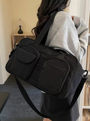 Black nylon duffle bag with multiple pockets and adjustable strap.