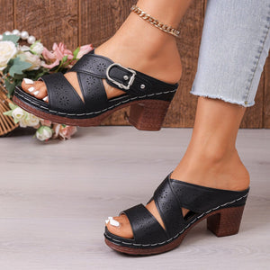 Black laser-cut criss-cross block heel sandals with buckle detail.