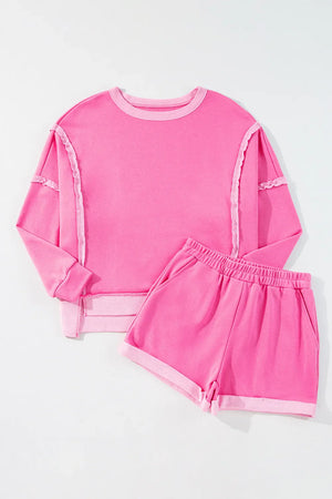 Fuchsia pink cotton loungewear set with contrast trim on crewneck sweatshirt and shorts.