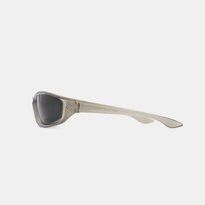Sculpted sport sunglasses in translucent gray with dark lenses and silver stud details.