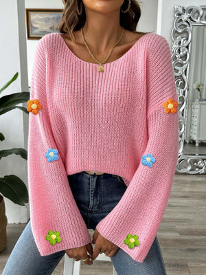Dusty pink knit sweater with embroidered floral appliques on sleeves, featuring a scoop neck and long sleeves.