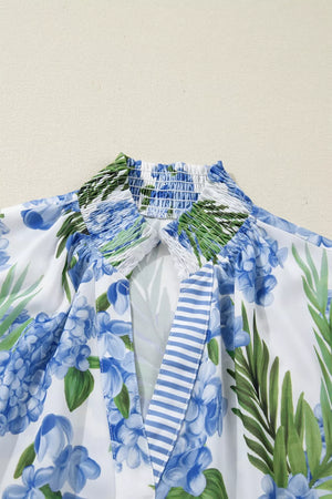 White V-neck blouse with blue hydrangea floral print and smocked neckline detail
