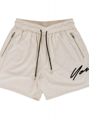 Beige BigFit jogger shorts with drawstring, zip pockets, and black script logo.