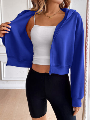 Royal blue cropped hooded zip-up sweatshirt with a white tank top and black shorts.