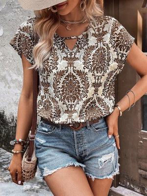 Damask print blouse with keyhole neckline and short sleeves, styled with denim shorts.