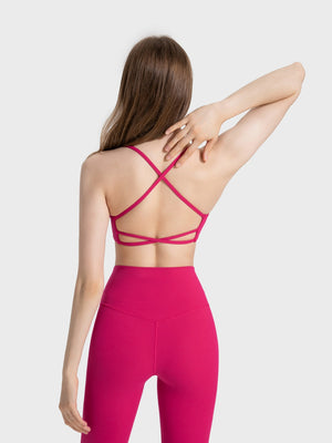 Fuchsia pink active crop top with strappy back detail and crisscross straps.