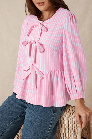 Blush pink striped peplum blouse with multiple bow embellishments and puff sleeves.