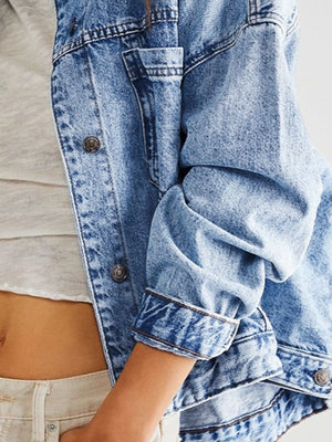 Oversized denim trucker jacket in light blue wash with button details and folded cuffs.