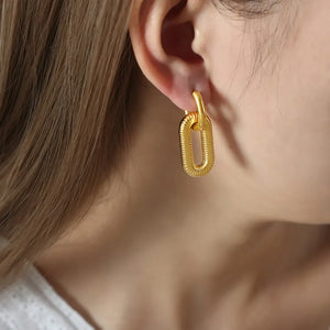 Gold textured oval link earrings with a ribbed surface detail.