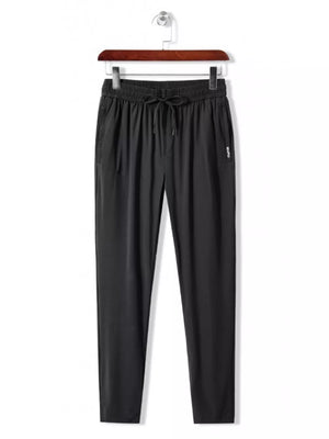Men's black drawstring active pants with side logo detail.