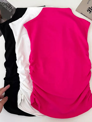 Textured ruching mock neck tank top in fuchsia, white, and black with draped detail.