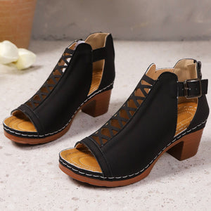 Black criss-cross cut-out block heel sandals with ankle strap and buckle closure.