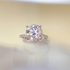 Sterling silver ring with large round clear solitaire stone and small accent stones on band.