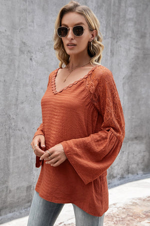 Orange-red blouse with lace sleeves and scallop trim, V-neck, bell sleeves.
