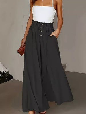 Dark blue wide-leg pants with paperbag waist and button detail.