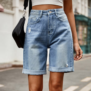 Medium wash denim boyfriend shorts with rolled hems and distressed details.