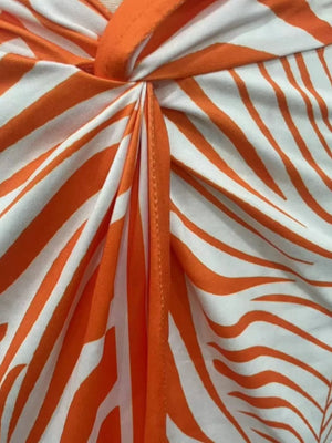 Orange red midi skirt with twisted knot detail and side slit, featuring a zebra print.