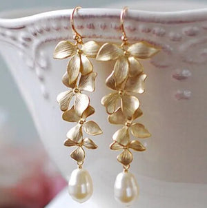Gold cascading flower drop earrings with pearl accents.