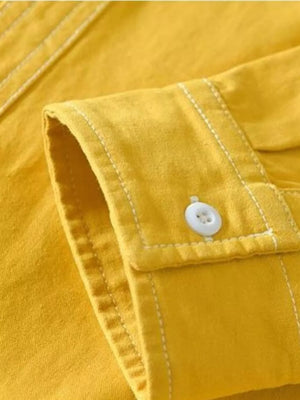 Yellow men's casual shirt with contrast stitching and button cuff detail.