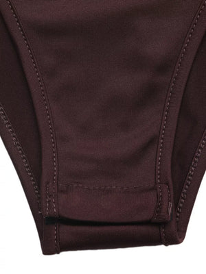 Bodysuit detail showing snap closure and stitching on dark brown fabric.