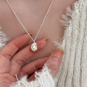 Silver necklace with lustrous freshwater pearl pendant, delicate chain.