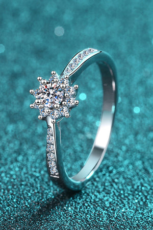 Silver moissanite ring with a starburst cluster and pavé band.