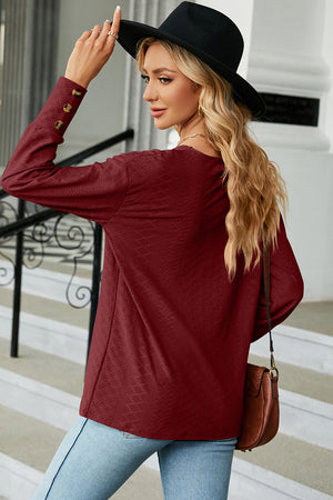 Burgundy diamond-textured v-neck blouse with button cuff details