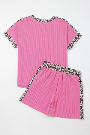 Pink ribbed pajama set with crew neck top and shorts featuring leopard trim details.