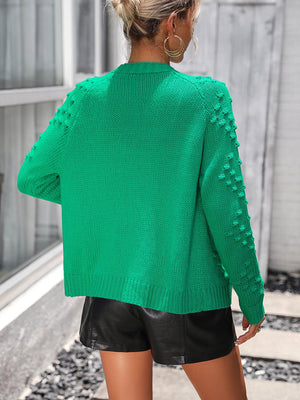 Green acrylic cardigan with textured sleeve details and ribbed hem.