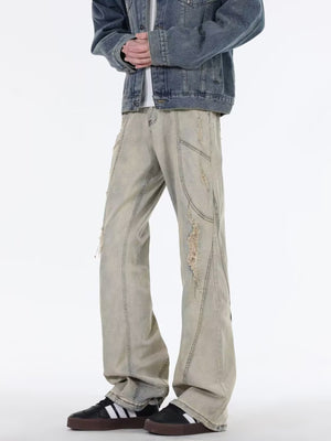 Men's beige wide leg jeans with distressed details and paneling.