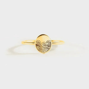 Gold band ring with engraved wave pattern on oval face