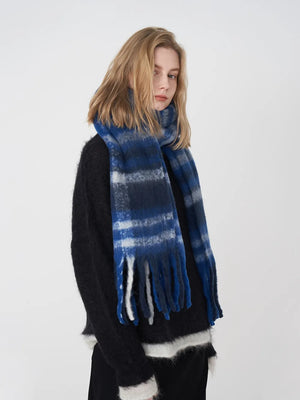 Textured plaid fringe scarf in blue/white/gray plaid with soft fringe detail.