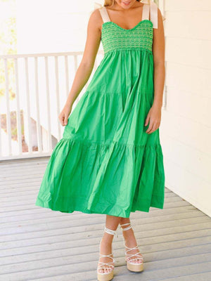 Green tiered midi dress with smocked bodice and tie shoulder straps.