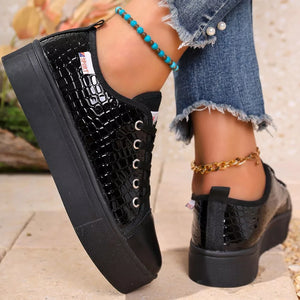 Black crocodile embossed platform sneakers with a chunky sole.