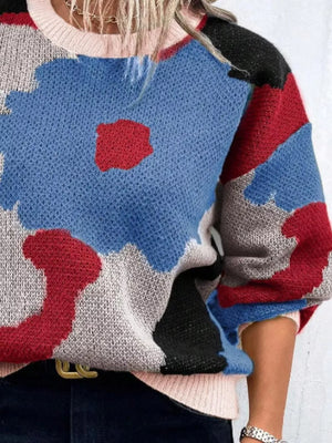 Abstract floral knit sweater with round neck in blue, red, grey, and black colorblock.