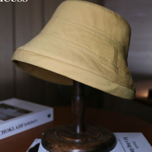 Cotton bucket hat in tan with stitched details for sun protection.