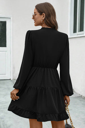 Black tiered ruffle sleeve mini dress with elastic waist and ruffled hem.