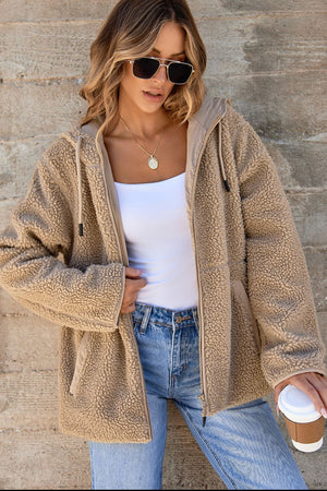 Sherpa-lined hooded jacket in khaki with contrast lining and zipper closure.