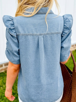 Light blue denim shirt with ruffled short sleeves and back pleats.