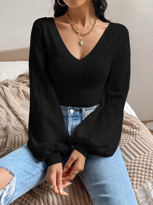 Black textured chevron blouson top with V-neck and voluminous sleeves