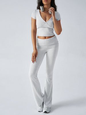 Light gray loungewear set with ruched waistband flared pants and a v-neck cropped top.