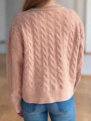 Dusty pink cable knit cardigan with puff sleeves and ribbed hem.