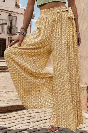 Yellow geometric print wide-leg palazzo trousers with a tie waist detail.