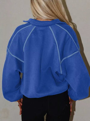 Blue cotton sweatshirt with snap collar and contrast stitching, relaxed fit.