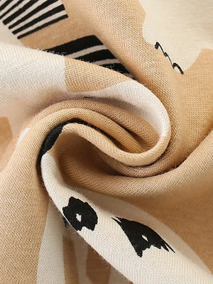 Beige cotton toddler ensemble with abstract dinosaur print and black stripes.